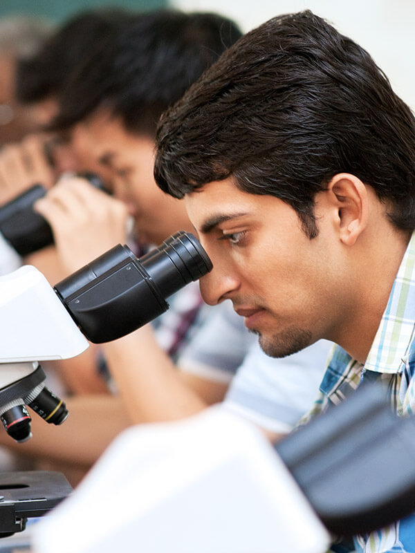 Indian students looking into microscopes